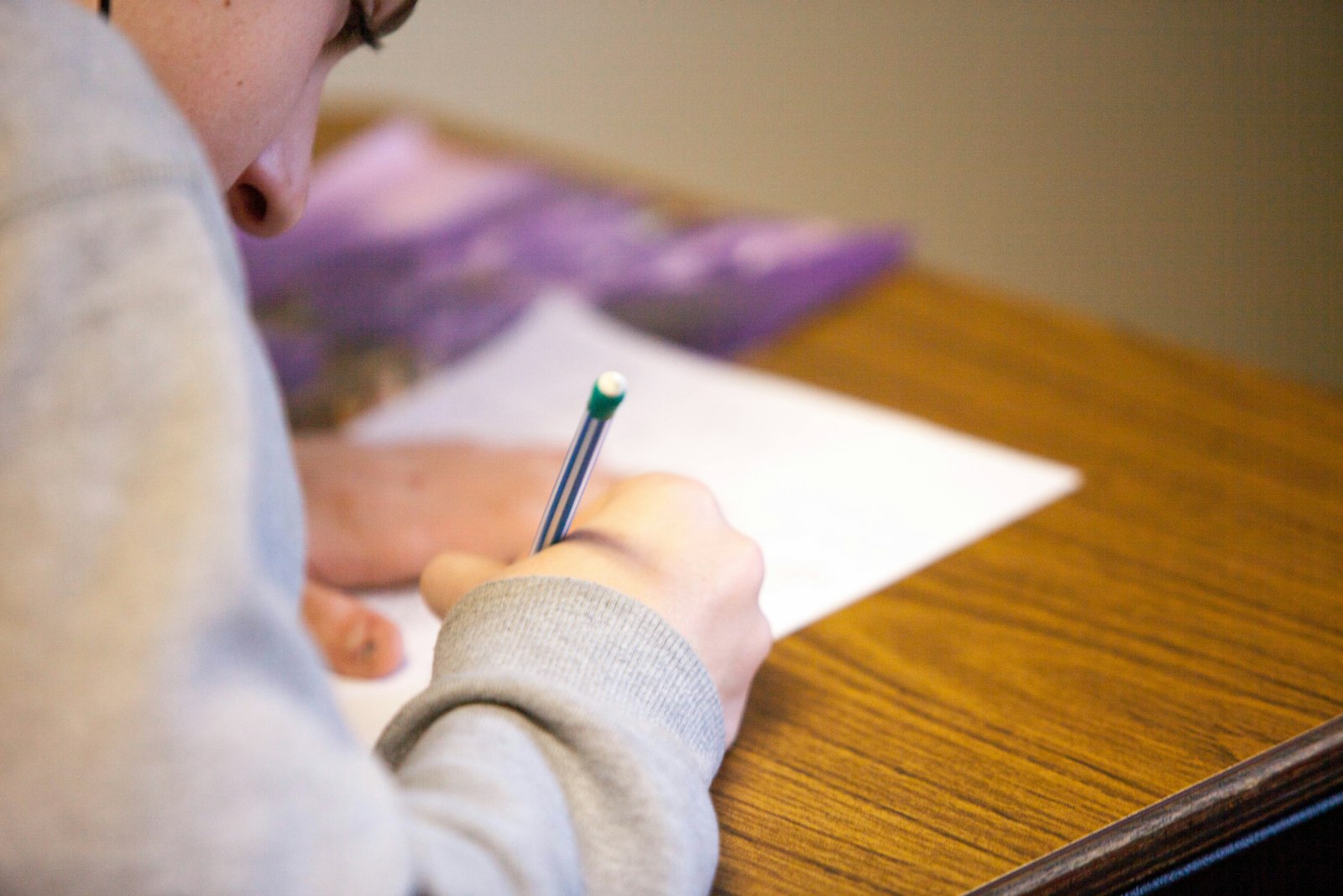 A high school student writing during an exam